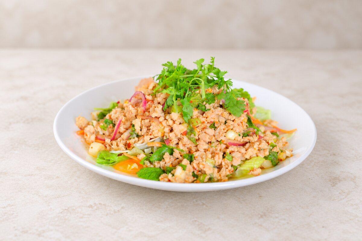 A minced-meat salad with herbs and red onion on a bed of lettuce.