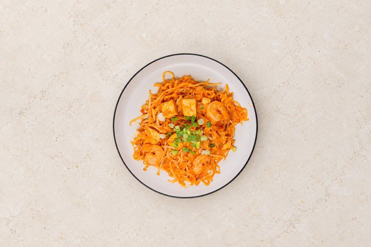 Rice noodles with prawns and tofu, seen from above.